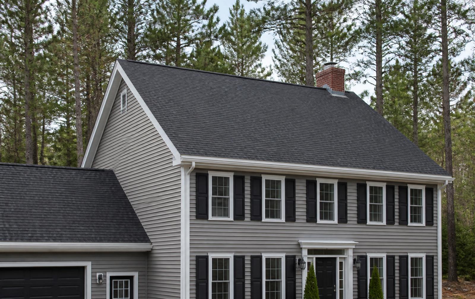 Maine colonial home with a completed charcoal architectural shingle roof replacement